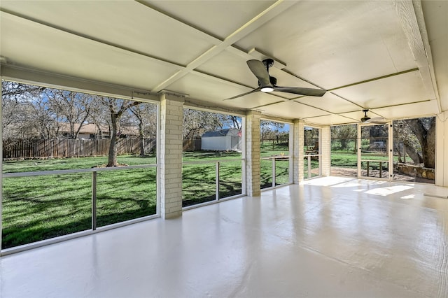 unfurnished sunroom featuring ceiling fan