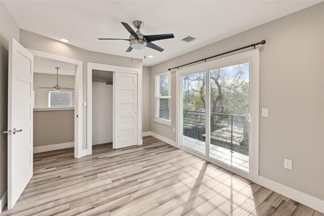 unfurnished bedroom with ceiling fan, access to exterior, a closet, and light wood-type flooring