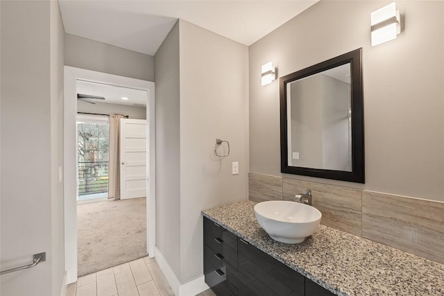 bathroom with tasteful backsplash, vanity, and baseboards