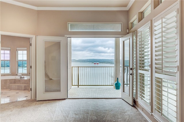 entryway featuring french doors, a water view, ornamental molding, and carpet floors