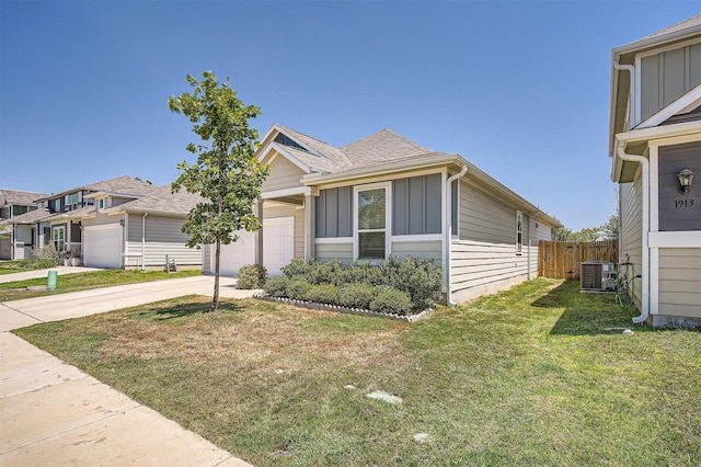 view of front of house with cooling unit, a front yard, and a garage