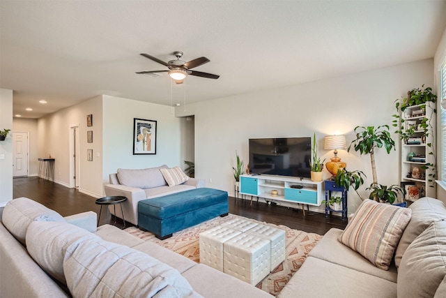 living room featuring ceiling fan and dark hardwood / wood-style floors