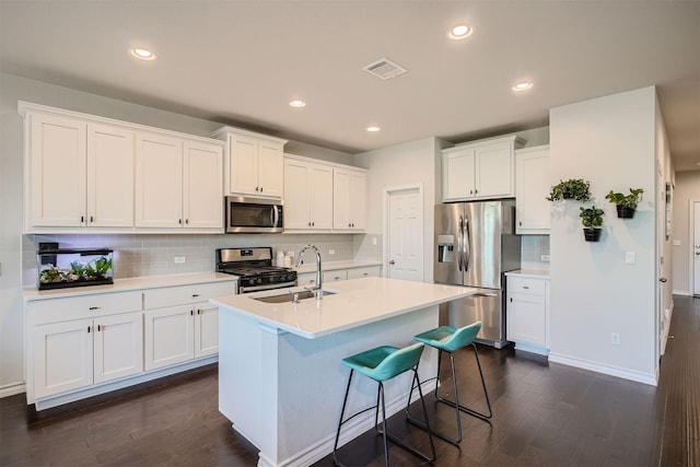 kitchen featuring white cabinets, appliances with stainless steel finishes, and a kitchen island with sink