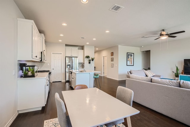 dining room featuring ceiling fan, dark wood-type flooring, and sink