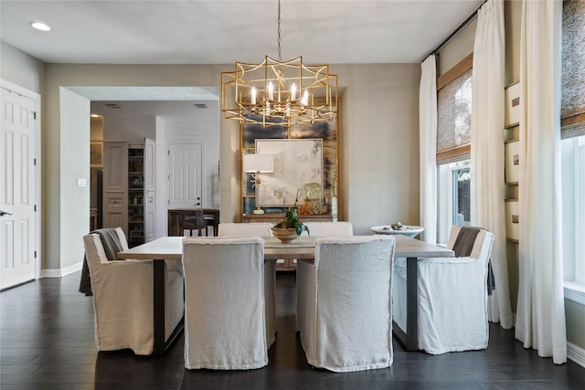 dining area featuring a chandelier, dark wood-style flooring, and baseboards