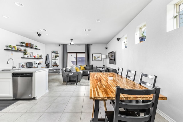 tiled dining space with ceiling fan and sink