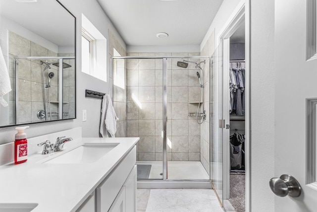 bathroom featuring tile patterned floors, walk in shower, and vanity