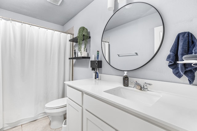 bathroom featuring vanity, toilet, tile patterned floors, and a textured ceiling