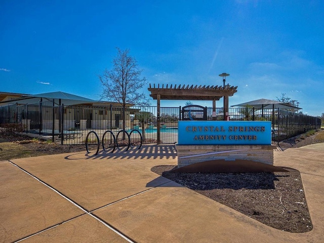 view of property's community with a pool and a pergola