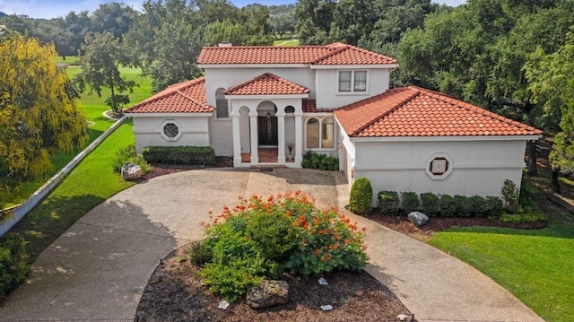 mediterranean / spanish-style home featuring a front yard