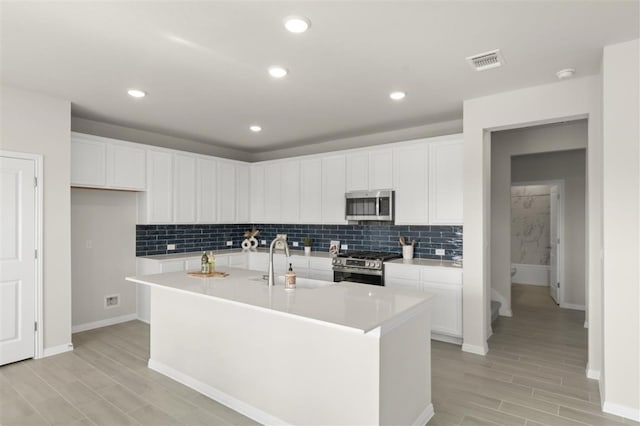308 Yellowstone Dr, Kyle, TX 78640 - kitchen with a sink, stainless steel appliances, baseboards, tasteful backsplash, and visible vents