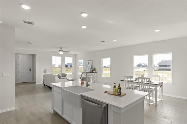 308 Yellowstone Dr, Kyle, TX 78640 - kitchen featuring stainless steel dishwasher, baseboards, light wood-type flooring, light countertops, and a sink