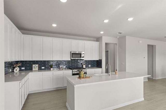 308 Yellowstone Dr, Kyle, TX 78640 - kitchen with an island with sink, light countertops, appliances with stainless steel finishes, and tasteful backsplash