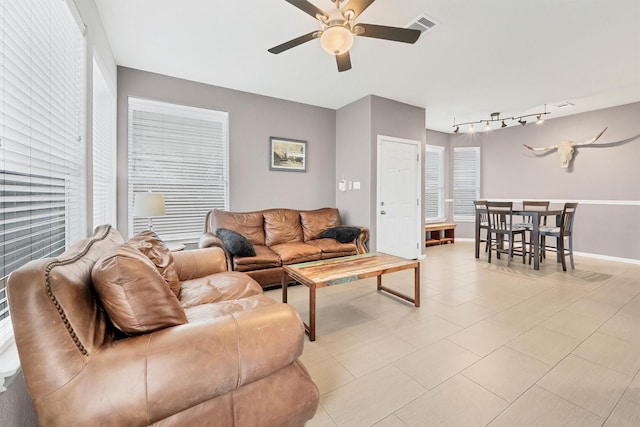 tiled living room featuring rail lighting and ceiling fan