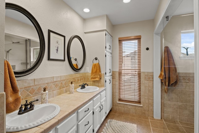 bathroom with tile walls, vanity, and tile patterned floors