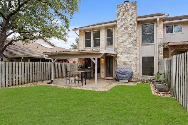 back of house with a patio and a lawn