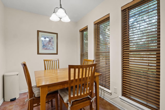 tiled dining area featuring an inviting chandelier