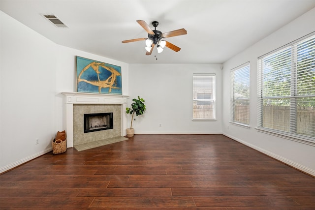 unfurnished living room featuring ceiling fan, dark wood-type flooring, and a fireplace