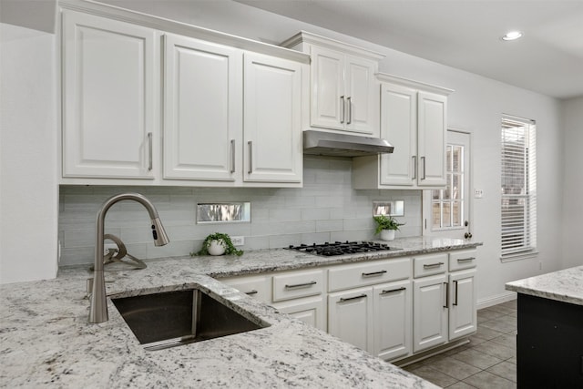 kitchen featuring white cabinets, stainless steel gas cooktop, and sink