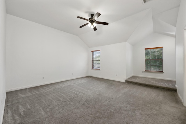 carpeted empty room with vaulted ceiling and ceiling fan