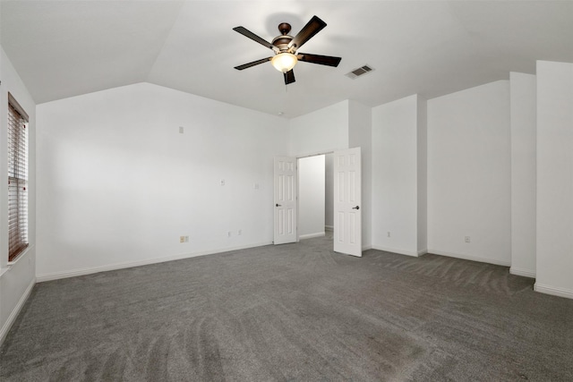 unfurnished bedroom with ceiling fan, lofted ceiling, and dark colored carpet