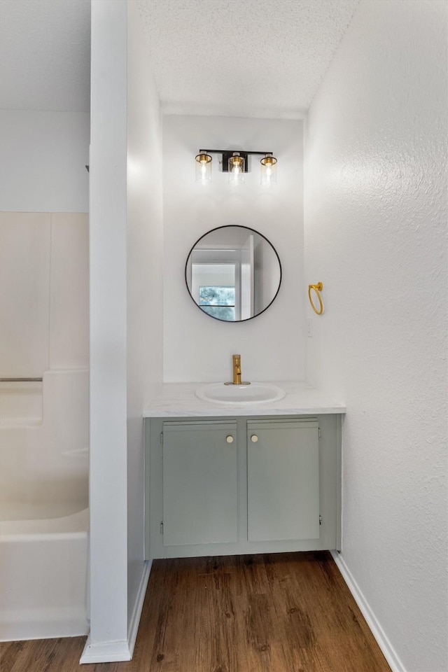 bathroom with hardwood / wood-style floors, a textured ceiling, and vanity