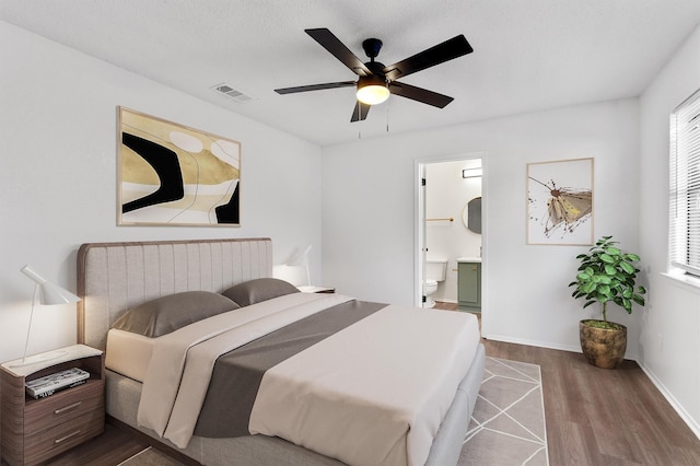 bedroom featuring wood-type flooring, connected bathroom, and ceiling fan