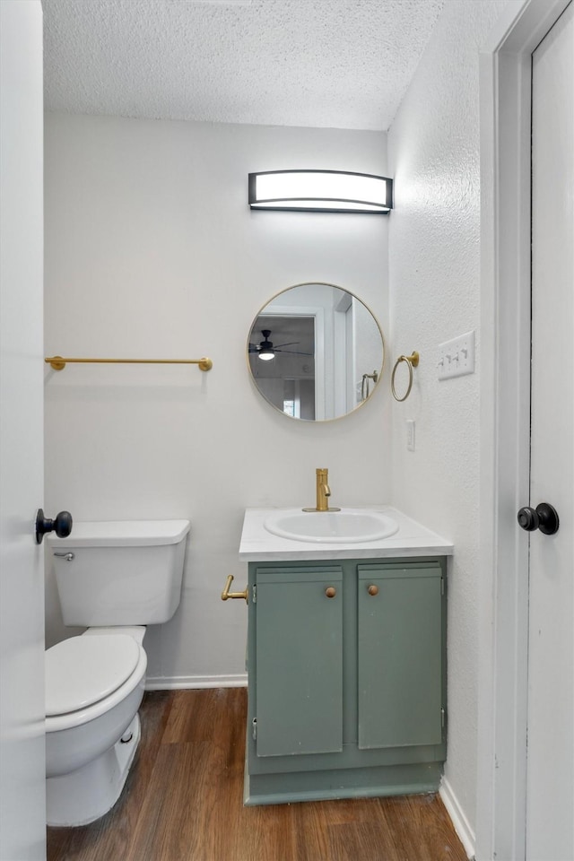 bathroom featuring vanity, toilet, a textured ceiling, and wood-type flooring