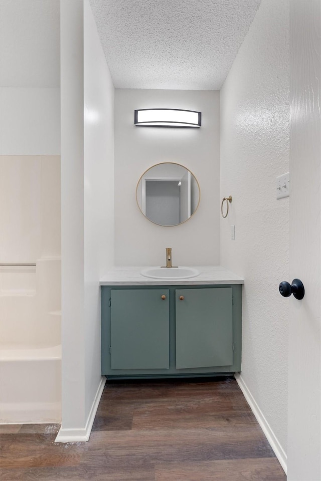 bathroom featuring wood-type flooring, vanity, and a textured ceiling