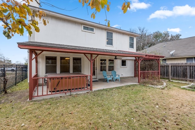 back of house featuring a hot tub, a patio, and a yard