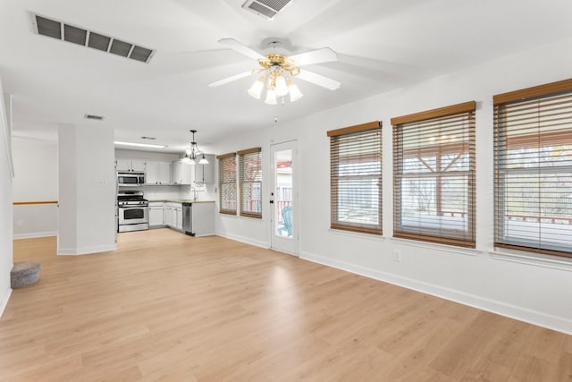 unfurnished living room with light hardwood / wood-style floors, sink, and ceiling fan with notable chandelier