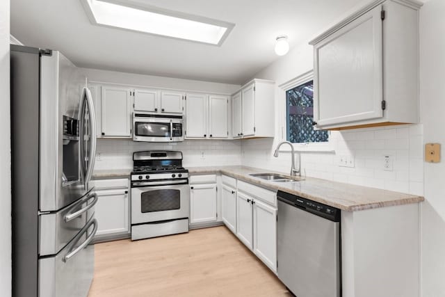 14829 Montoro Dr, Austin, TX 78728 - kitchen featuring stainless steel appliances, a sink, decorative backsplash, light wood-type flooring, and light stone countertops