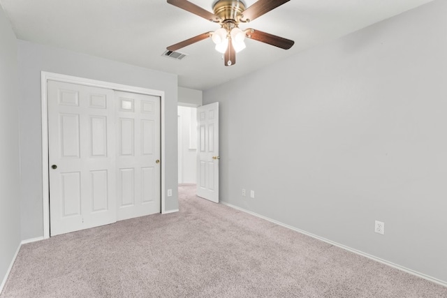 unfurnished bedroom with ceiling fan, a closet, and light colored carpet