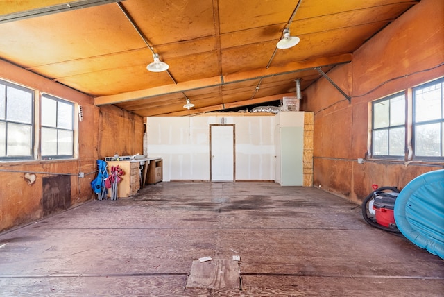 miscellaneous room with vaulted ceiling with beams, wooden walls, plenty of natural light, and wooden ceiling