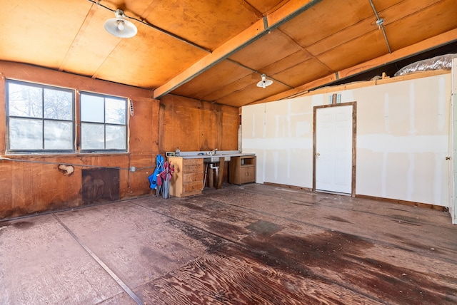 miscellaneous room featuring wooden walls and vaulted ceiling