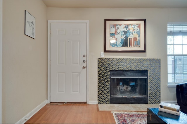 living room with hardwood / wood-style flooring and a tiled fireplace