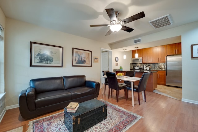 living room featuring ceiling fan and light wood-type flooring