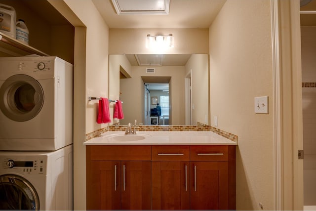 laundry area with sink and stacked washing maching and dryer