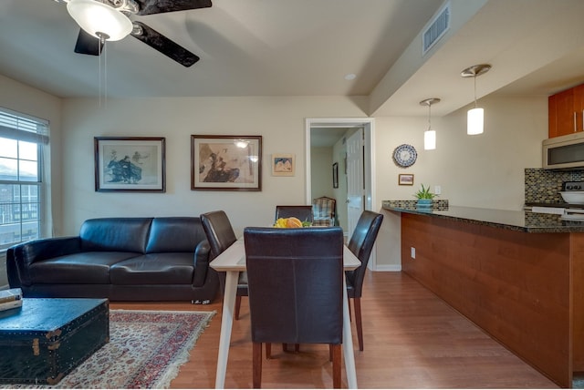 dining area with ceiling fan and light hardwood / wood-style floors