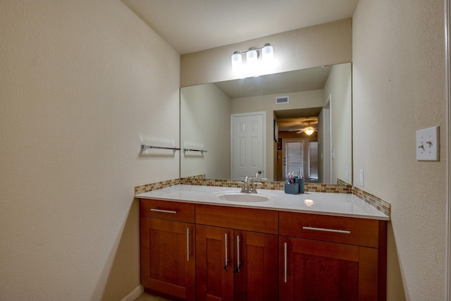 bathroom featuring tasteful backsplash, ceiling fan, and vanity