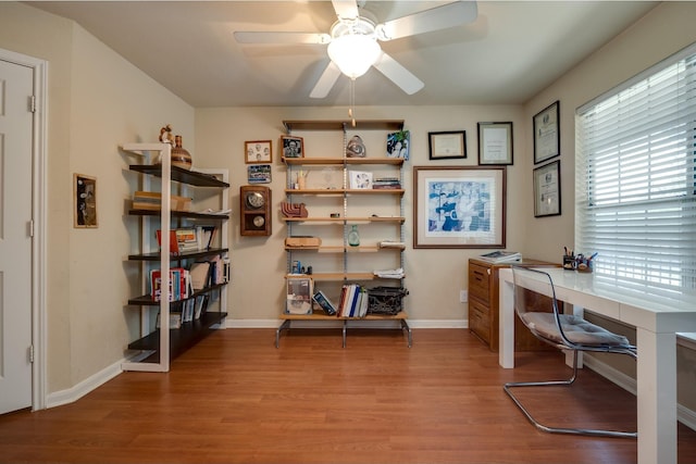 office space with light hardwood / wood-style flooring, ceiling fan, and built in desk