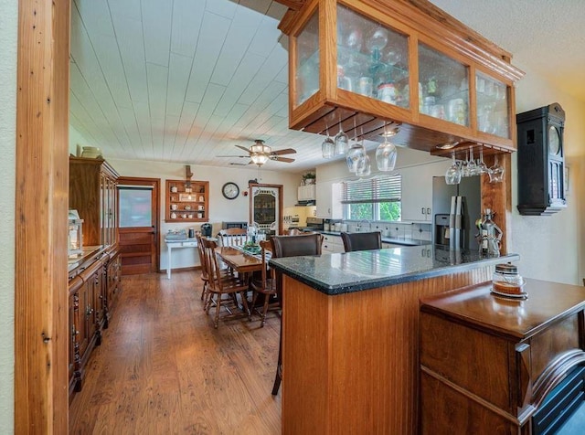 kitchen featuring kitchen peninsula, stainless steel fridge, dark hardwood / wood-style flooring, backsplash, and wood ceiling