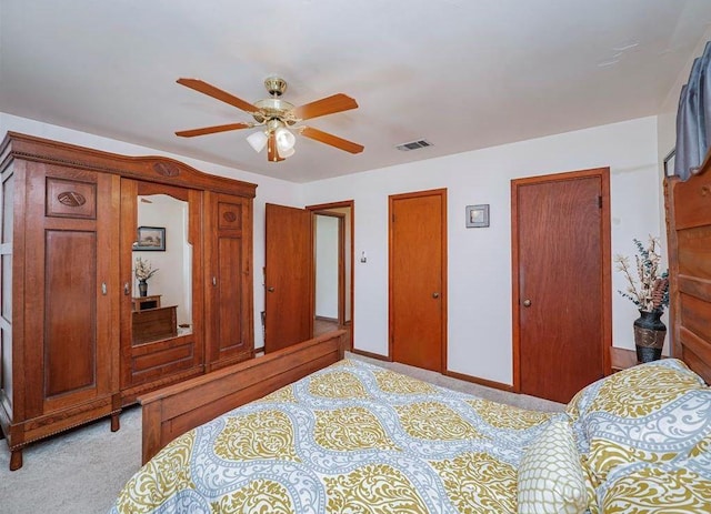 carpeted bedroom with multiple closets and ceiling fan