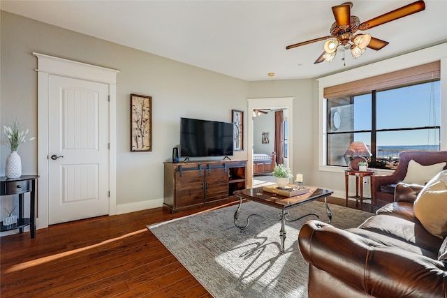 living room featuring ceiling fan and dark hardwood / wood-style flooring