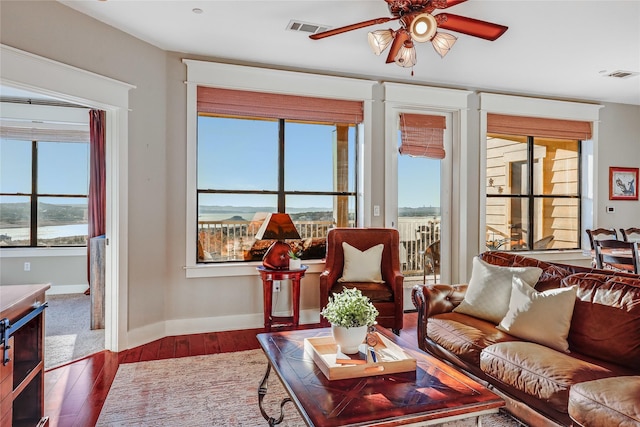 living room featuring ceiling fan and dark hardwood / wood-style flooring