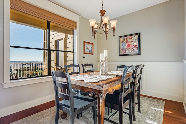 dining area featuring dark wood-type flooring and a notable chandelier