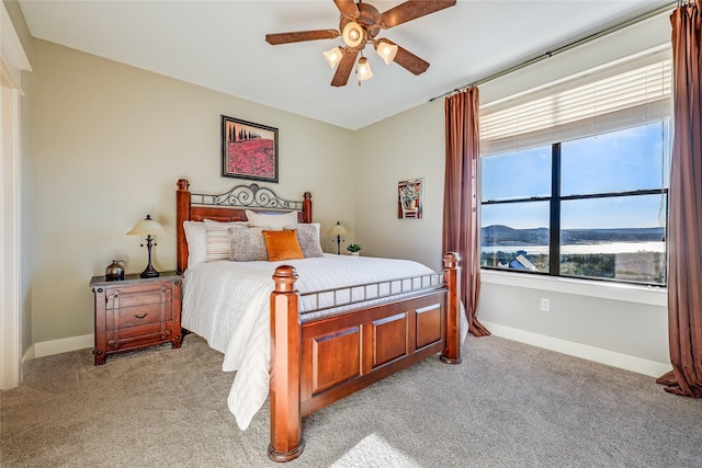 bedroom featuring a mountain view, ceiling fan, and light carpet