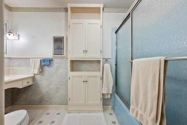 bathroom with bath / shower combo with glass door, toilet, and crown molding