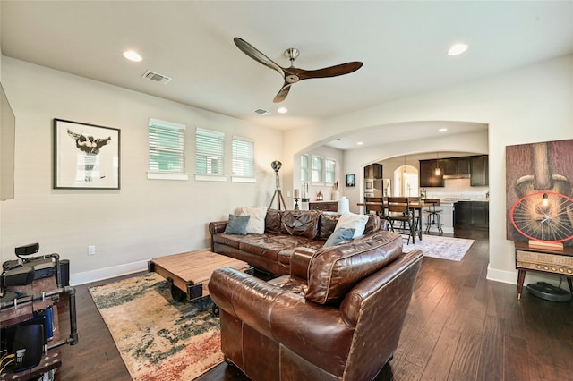 living room with ceiling fan and dark hardwood / wood-style flooring