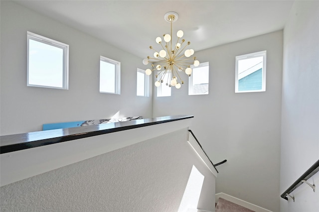 interior space with carpet, a wealth of natural light, and a chandelier